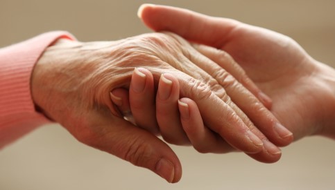 An older person holding hands